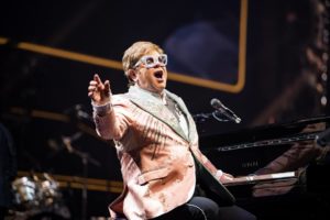 Elton John en concert jouant d'un piano