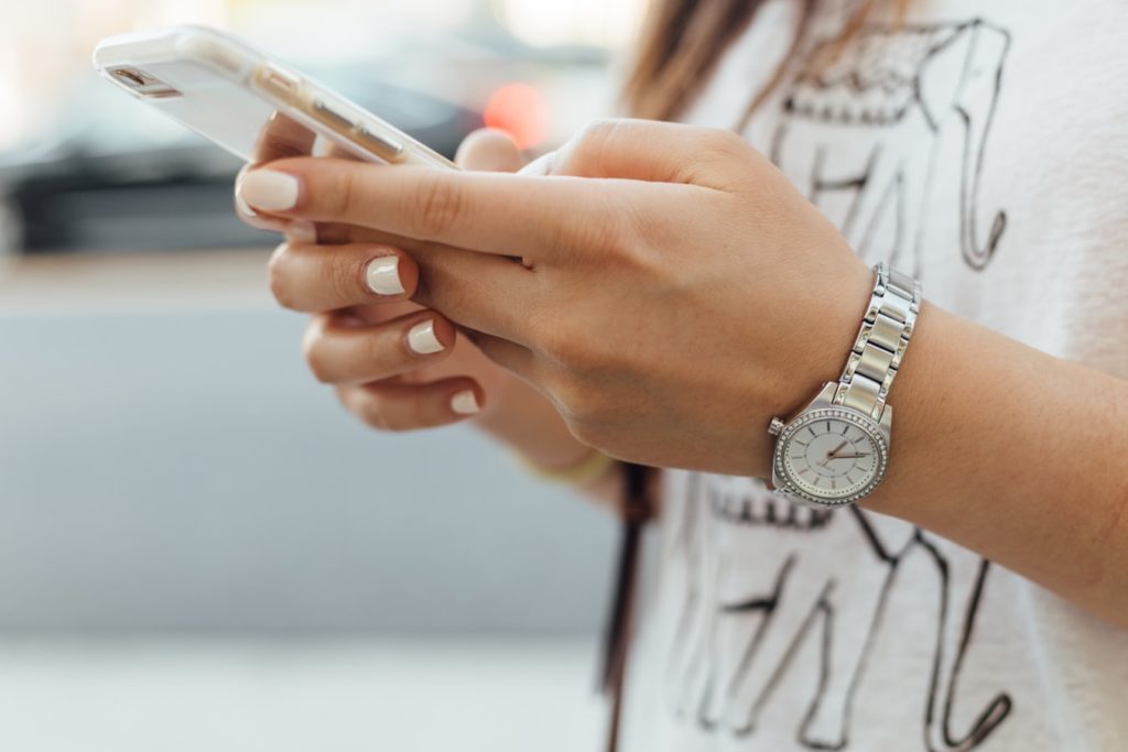 Une jeune femme manipulant son smartphone