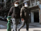 Deux jeunes gens ayant porté des masques dans une rue de Macau, région autonome de la côte sud de la Chine continentale, dans le delta de la rivière des Perles, en face de Hong Kong.