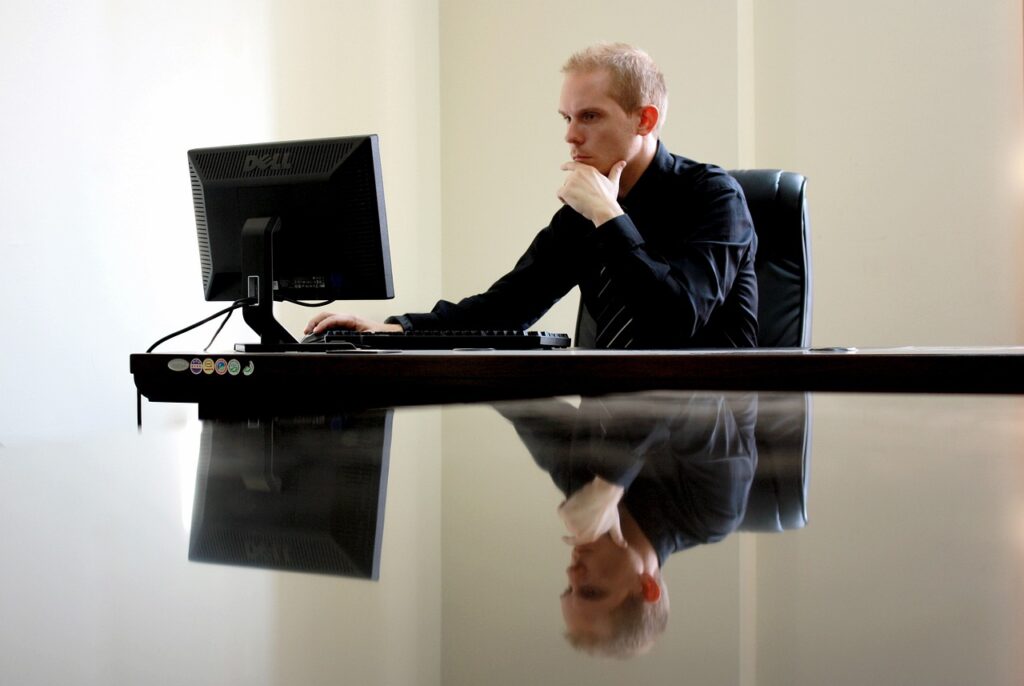 Un homme devant son ordinateur dans un bureau.