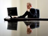 Un homme devant son ordinateur dans un bureau.